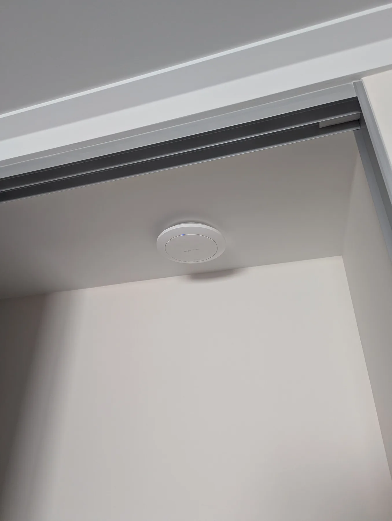 Discreet ceiling-mounted Wi-Fi access point installed near a hallway