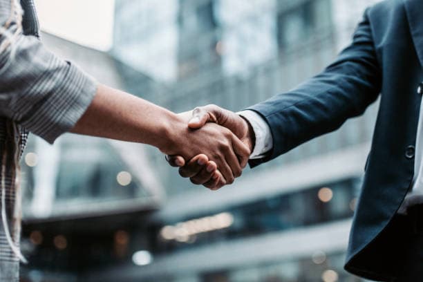 Two people shaking hands after reaching an agreement